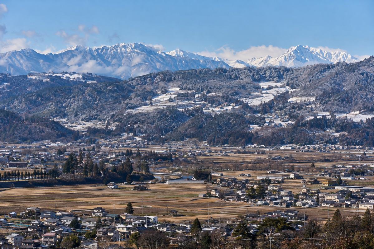標高の違う長野県の集落。手前の盆地のまちと、奥の山あいの雪景色